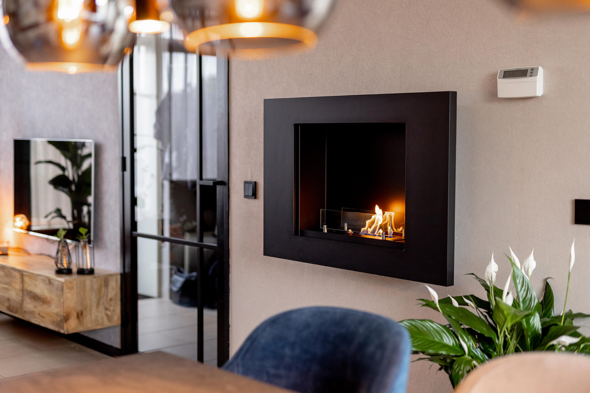 Burning bioethanol wall fireplace from Xaralyn in a livingroom