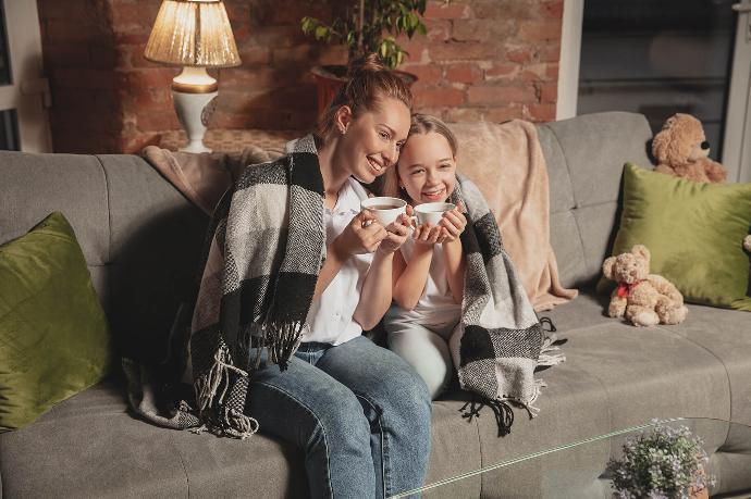 Famille sur le canapé sous une couverture